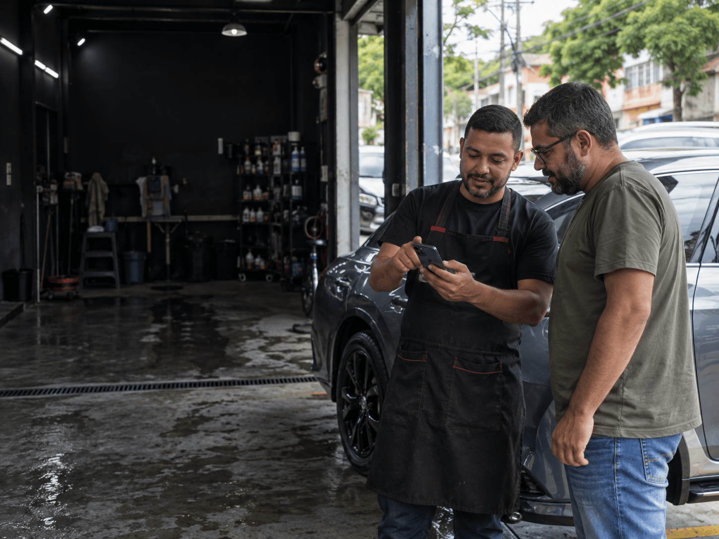 Profissional mostrando o site da estética automotiva para um cliente
